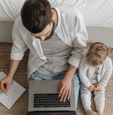Dad on laptop next to child